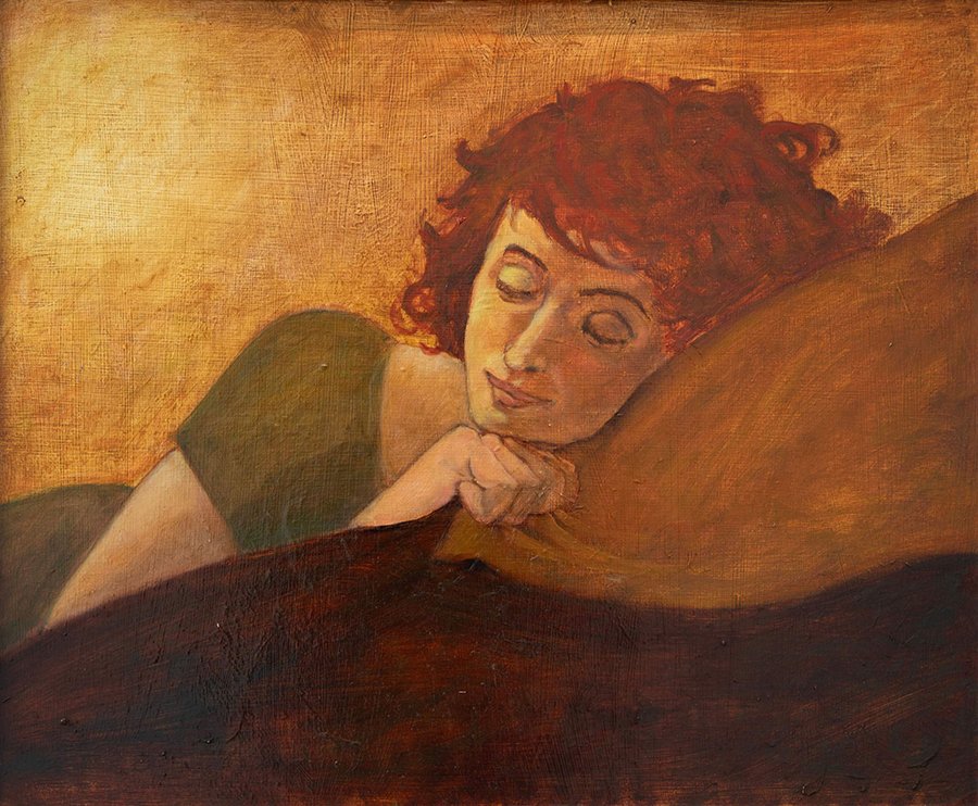 Closeup of young curly-haired woman in simple green dress sleeping on pillow